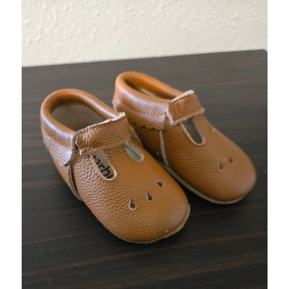 Brown leather Starbie baby moccasins with a T-strap design
